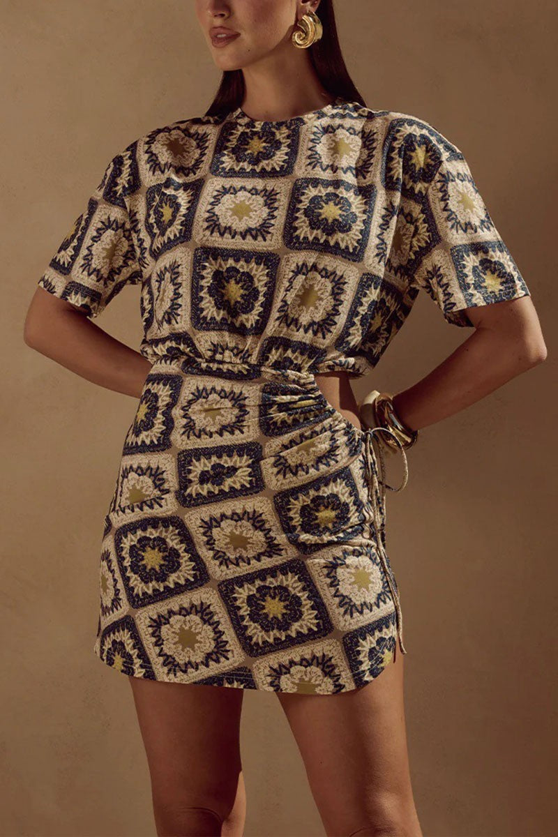 Close-up of side cutout and waist-tie detail on boho-inspired printed dress.