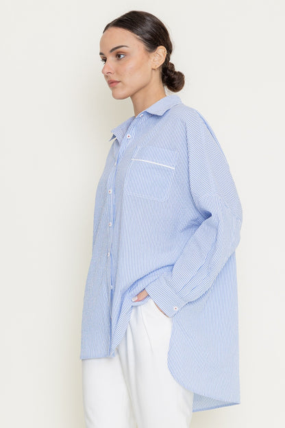 Back view of model wearing blue oversized striped shirt with relaxed tailoring