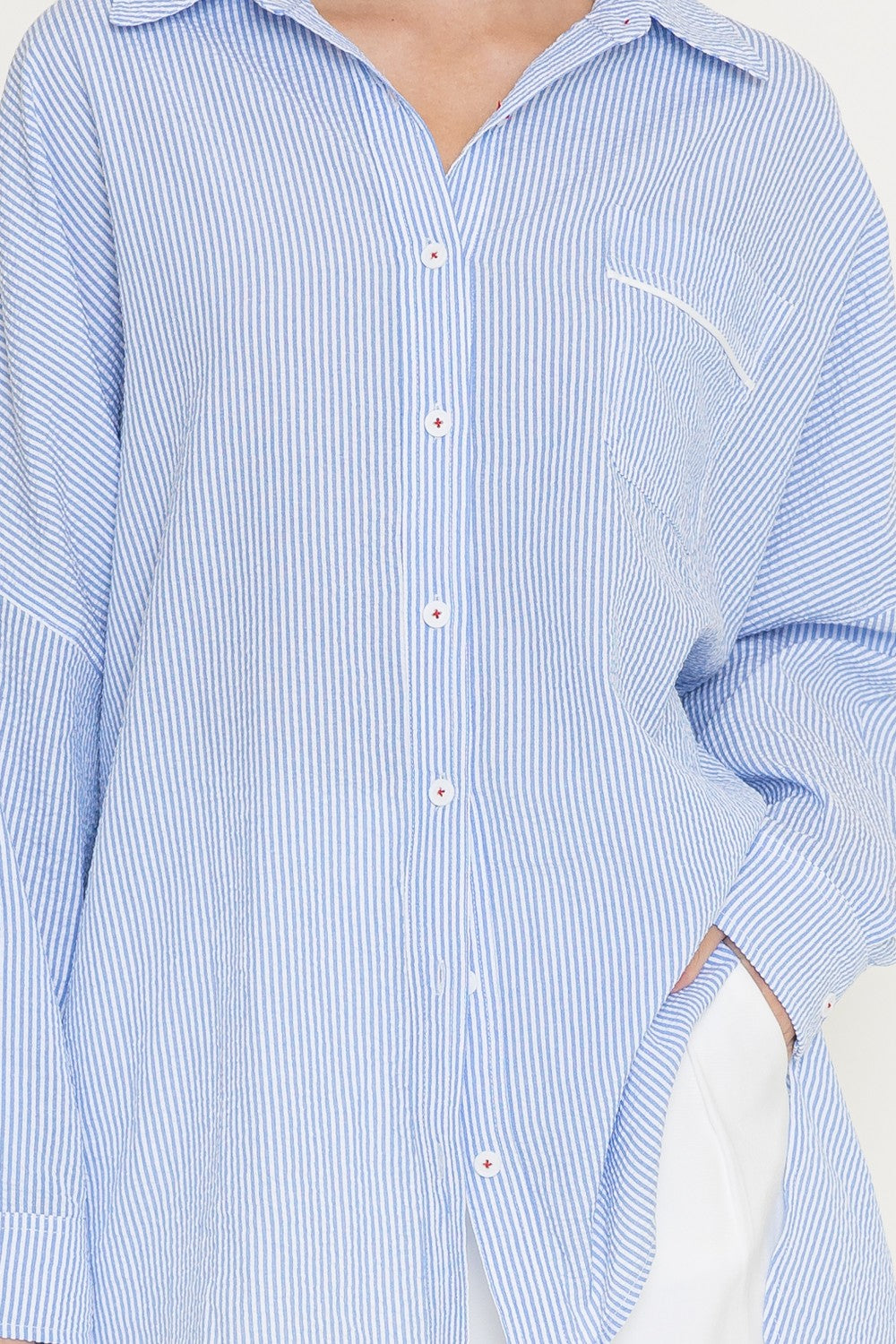 Close-up of blue striped collar and chest pocket detail on cotton shirt