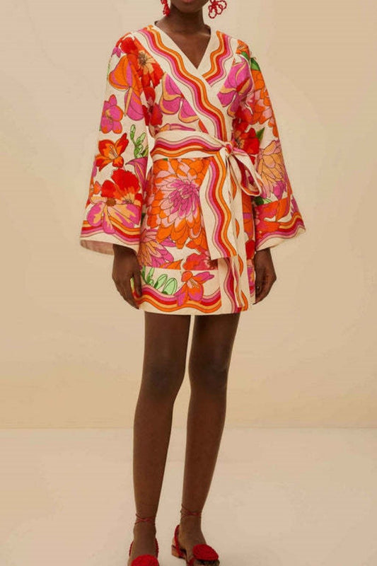 Front view of model wearing retro floral linen wrap mini dress with wide sleeves and self-tie belt